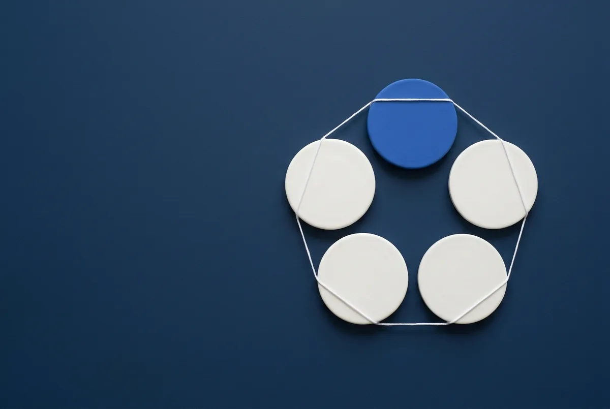 Cinq disques ronds en cercle, quatre blancs et un bleu, reliés par un fil blanc sur une surface marine